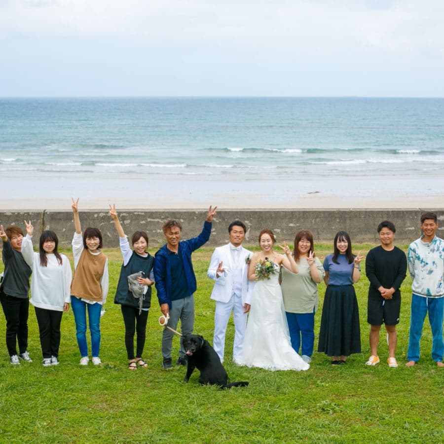 海岸バックに新郎新婦とご家族集合写真