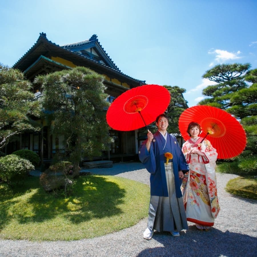 賓日館にて新郎新婦赤い傘を持って