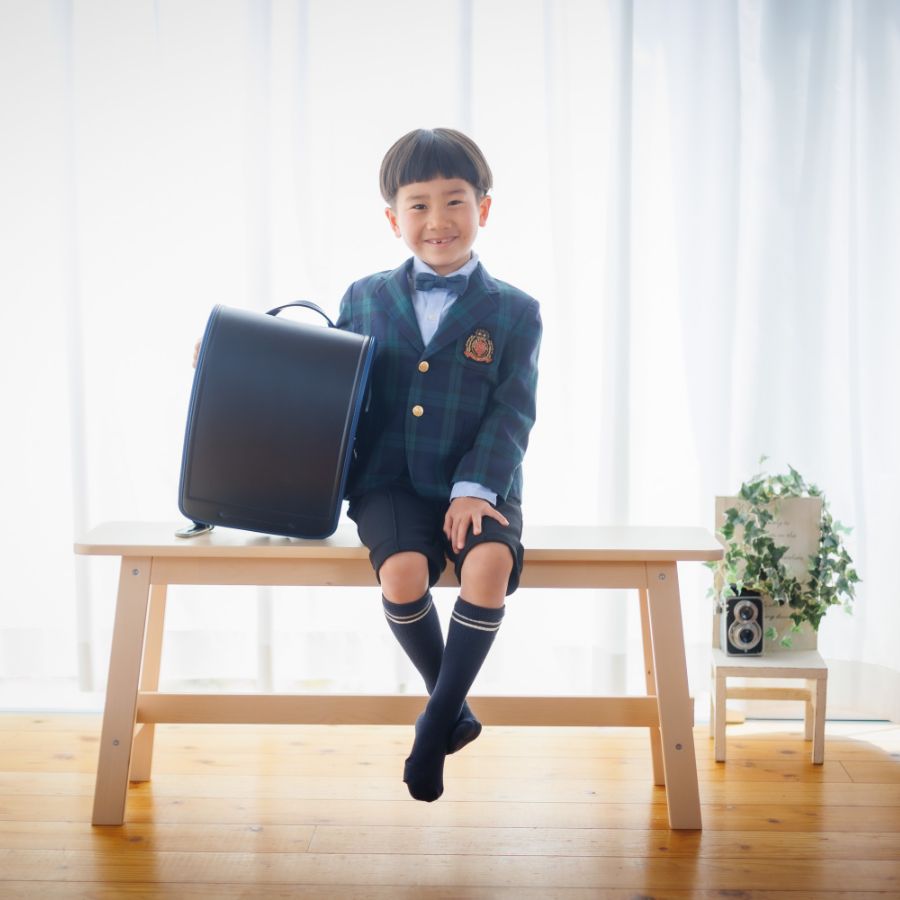 ランドセルを横において座っている男の子