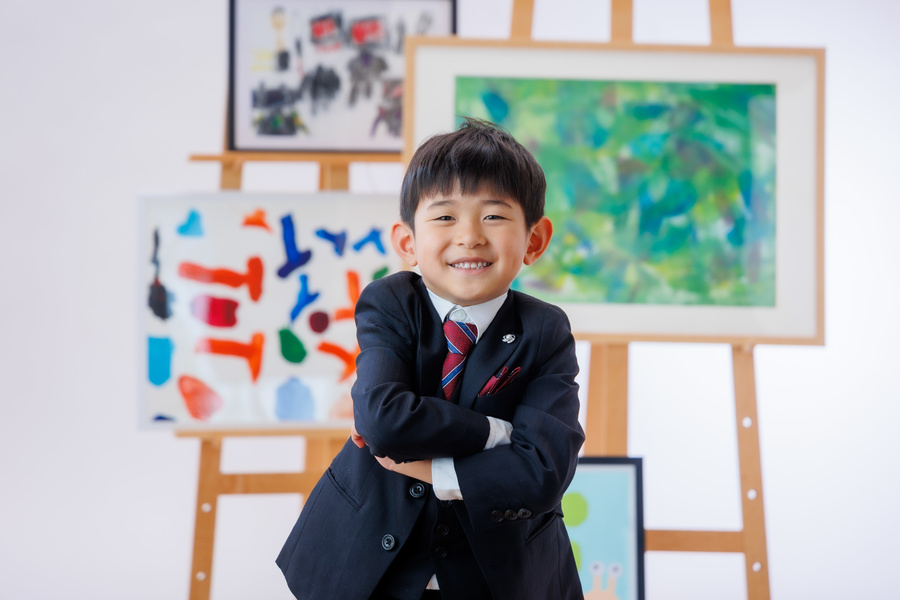 小学校入学記念写真男の子　自分が描いた絵をバックに