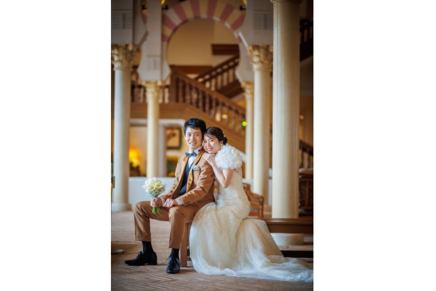 ホテル志摩スペイン村でフォトウェディング　新郎新婦座っていて新婦が新郎に寄りかかっている