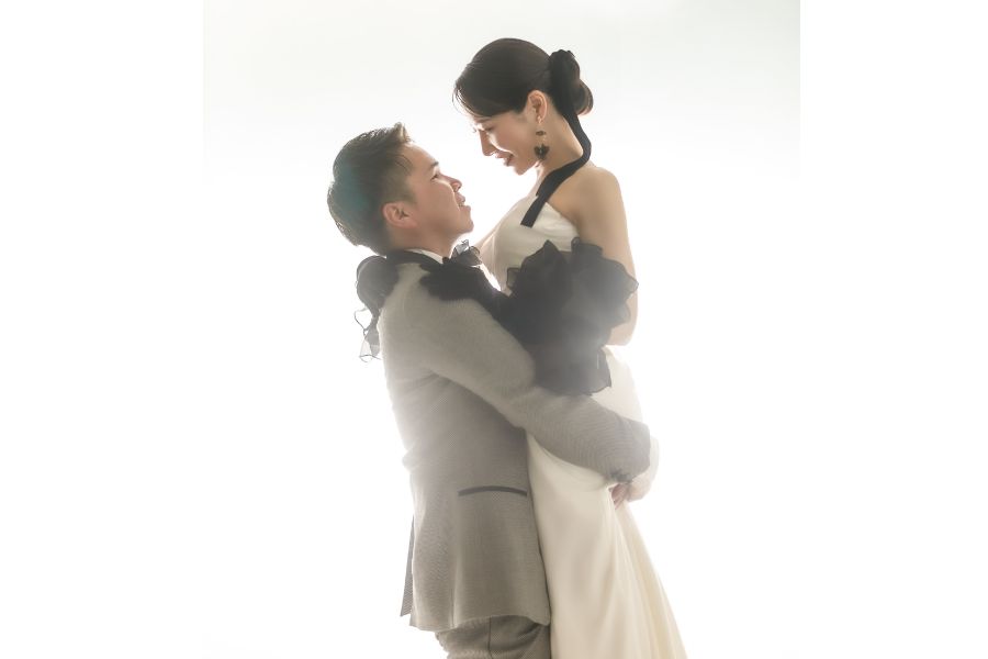 ウェディング前撮り　新郎がドレスの新婦を抱き上げて見つめ合っている