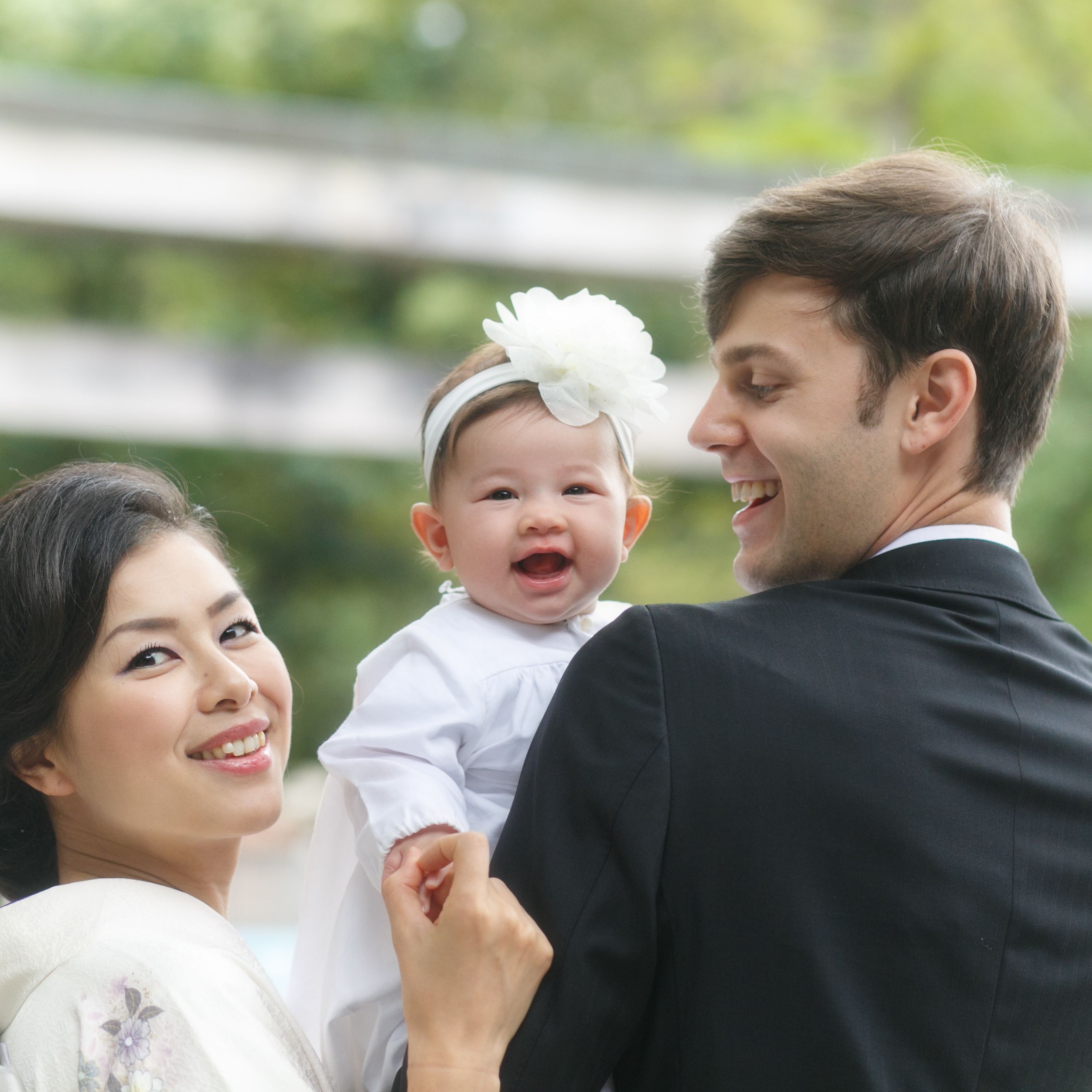 神社で赤ちゃんのお宮参りでの家族３人写真　真ん中で赤ちゃん　笑顔