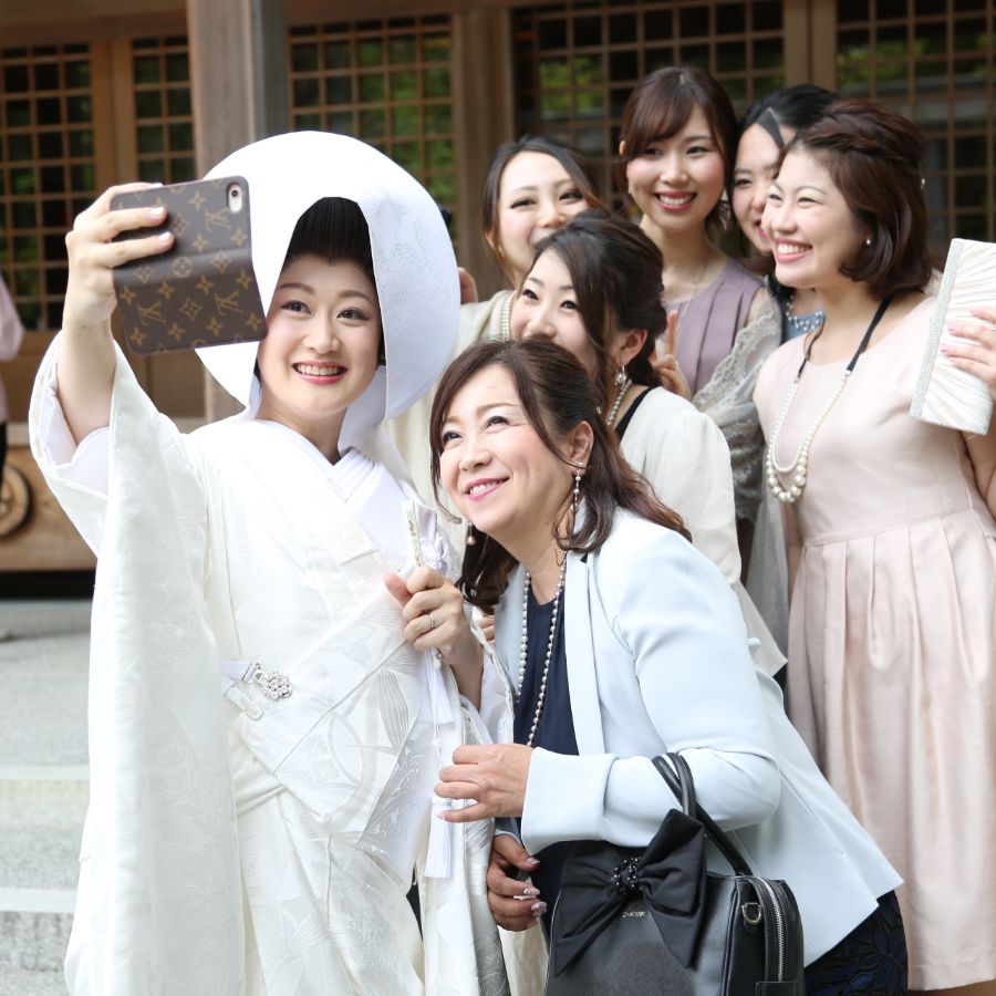 新婦がスマホを持って、友人たちと自撮り